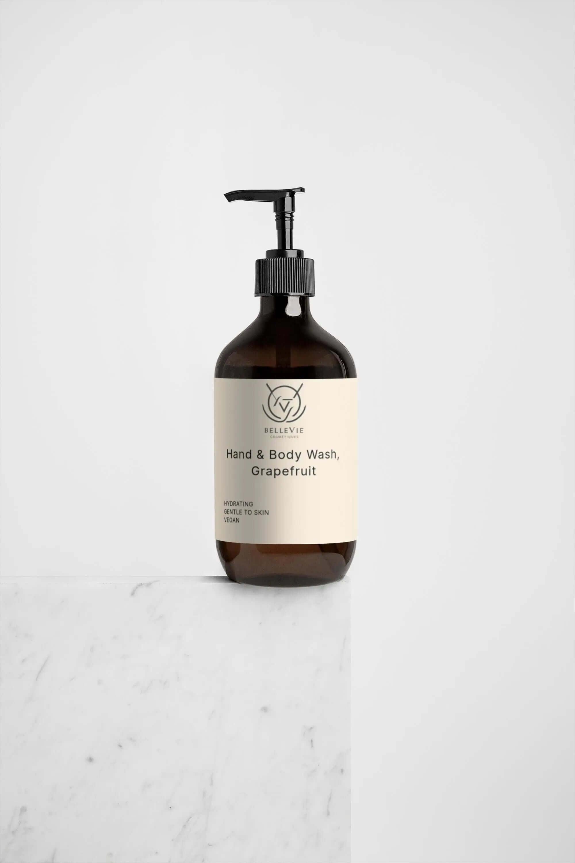 Brown bottle of hand and body wash grapefruti with a label on a marble surface.
