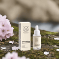 Bellevie AHA Peeling Concentrate 30ml bottle and box on a natural background with flowers.