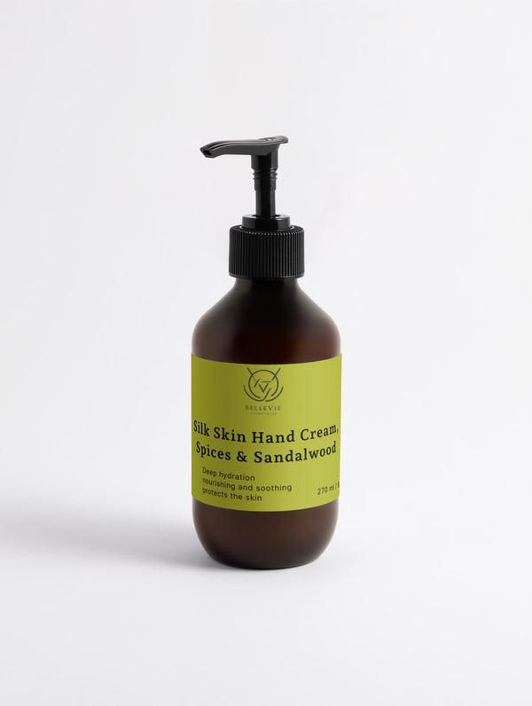 An amber glass pump bottle of Silk Skin Hand cream with a black pump and a lime green label, set against a plain white background.