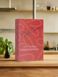 A collection box labeled 'Anti-Ageing Collection Box g' on a wooden surface, with a signature at the bottom, indicating it might be a branded product.