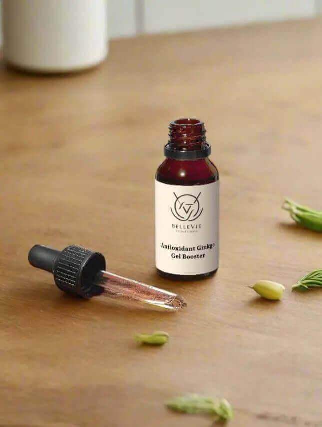 Bottle of Antioxidant Ginkgo Gel Booster 20ml with dropper on a wooden surface.