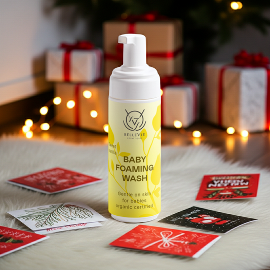 Baby foaming wash bottle with yellow label on a festive background with presents and cards.