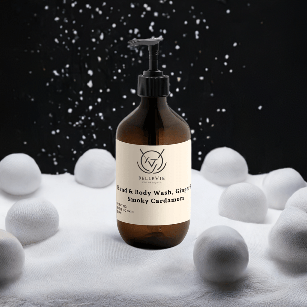 BelleVie Smoky Cardamom Hand & Body Wash 490ml amber bottle with large snowflake and snow on dark background – patchouli and amber vanilla natural body wash