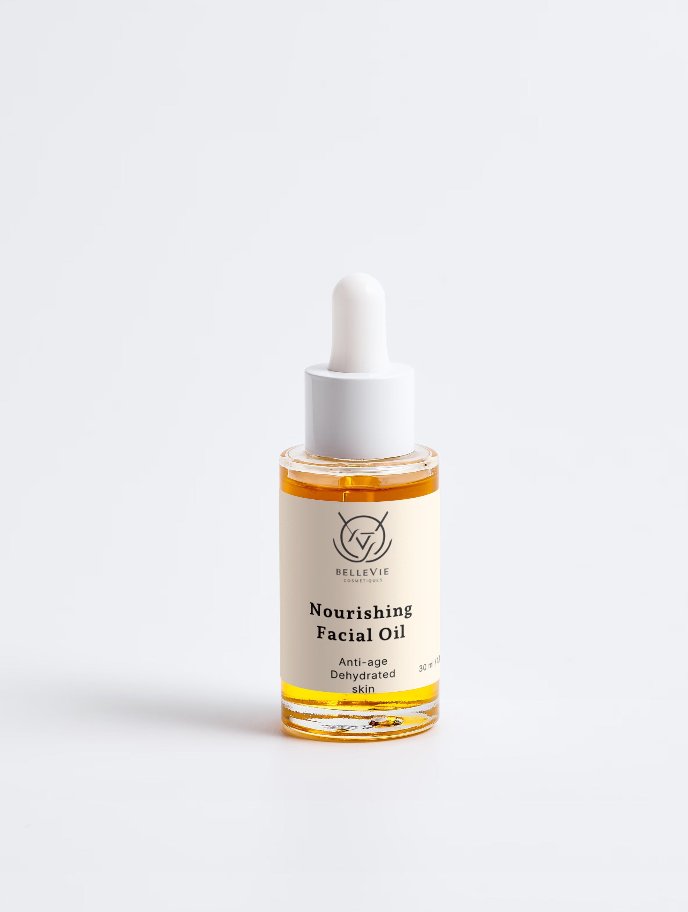 A small glass dropper bottle of Bellevie Cosmetics Nourishing Facial Oil , set against a seamless light gray background.