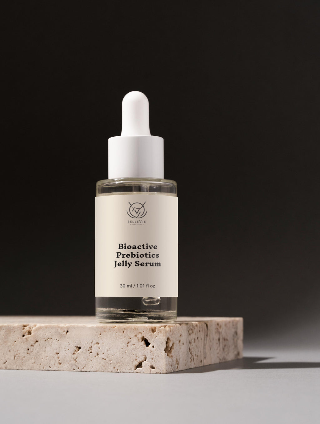 Bioactive Prebiotics Jelly Serum bottle on a stone surface with a black background