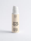 Brightening Face and Body Exfoliator with kojic acid Skincare product bottle with beige label on a light gray background