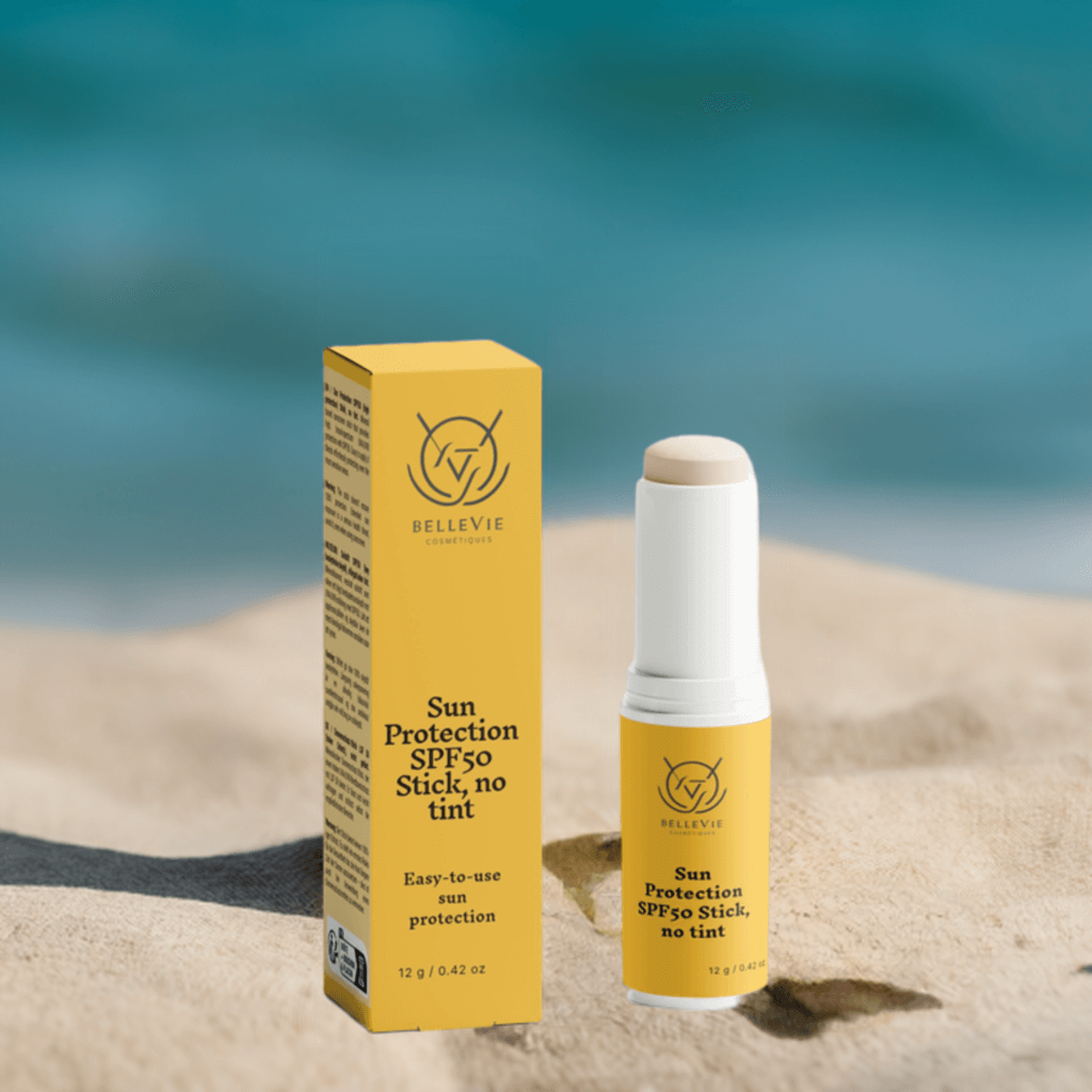 Sun protection SPF50 stick and packaging on sand with ocean background