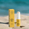 Sun protection SPF50 stick and packaging on sand with ocean background