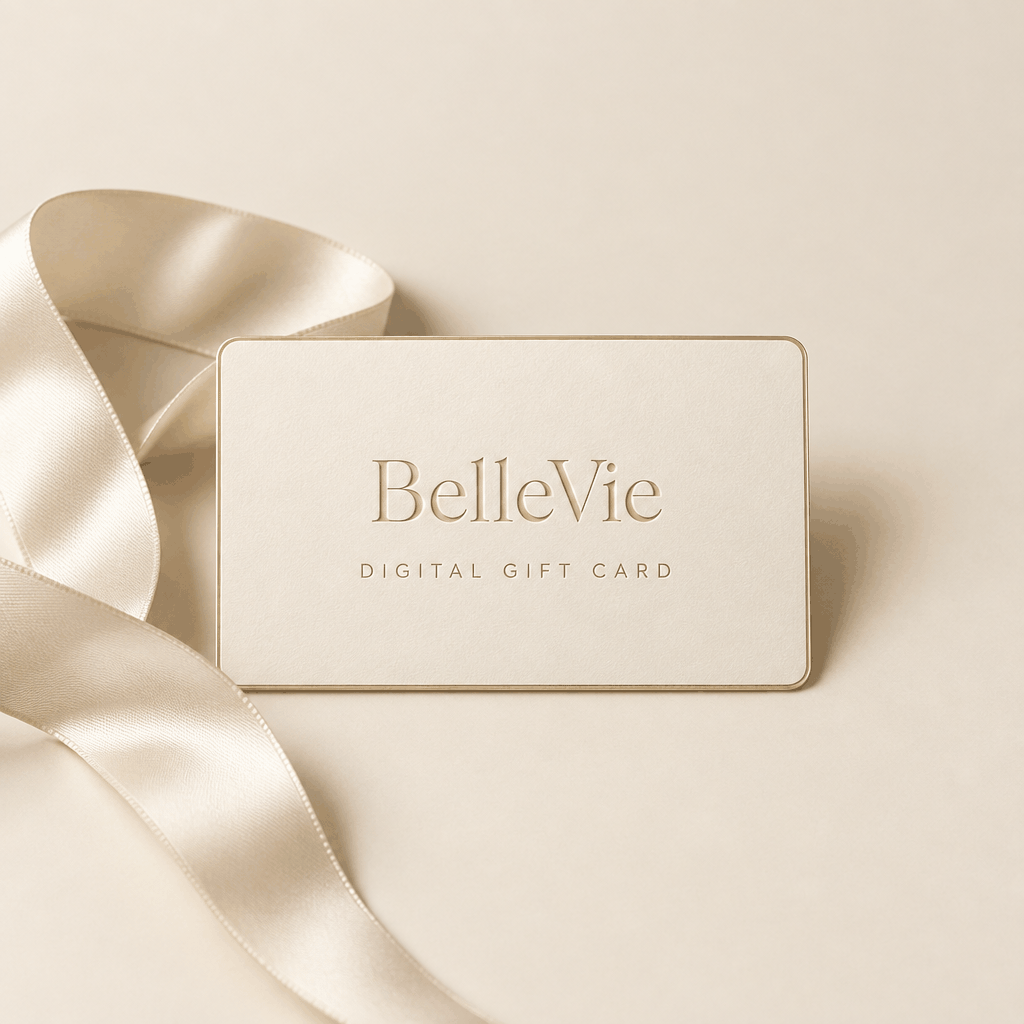 BelleVie Digital Gift Card shown as a cream card with gold lettering and a subtle gold border, beside a satin ribbon